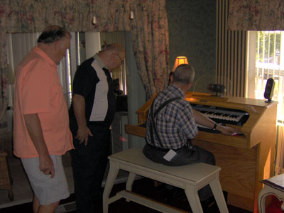 Click here to download a 2048 x 1536 JPG image of Tom Hoehn playing Dan Rowland's Mighty MidiTzer as Dan and Papa Bill look on.