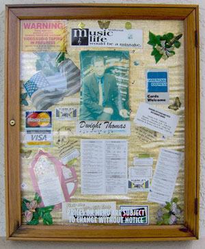 Click here to download a 1192 x 1423 JPG image of a framed collage outside the entrance to Roaring 20's Pizza and Pipes featuring memorabilia from Dwight Thomas.