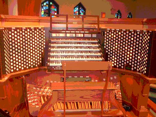 A modern 6-manual draw knob console controlling a huge Church Pipe Organ.