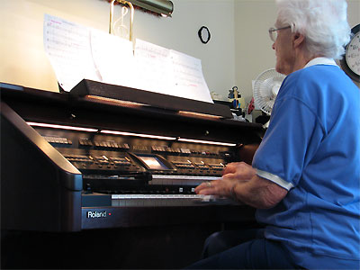 Click here to download a 2576 x 1932 JPG image showing Elenoir Winnemore at the console of the Mighty Roland Atelier digital residence organ.